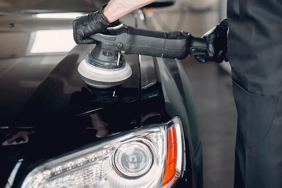 Ciemny samochód po detailingu w hali warsztatu