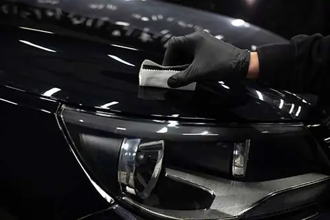 Ciemny samochód pokryty pianą przed aplikacją powłoki ceramicznej